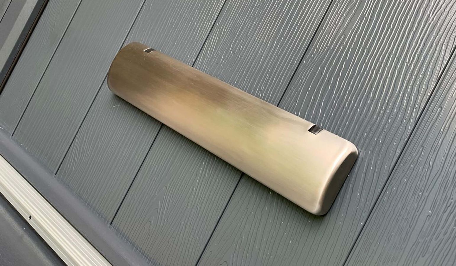 Sweet letterplate with a satin appearance on a grey door