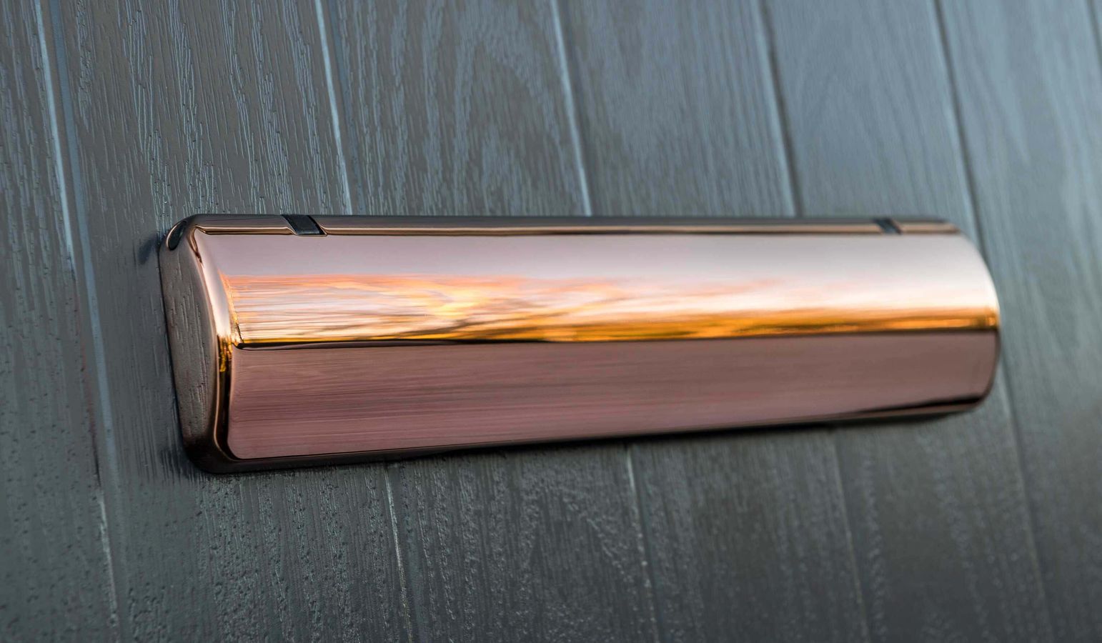 Sweet letterplate in rose gold on a grey door